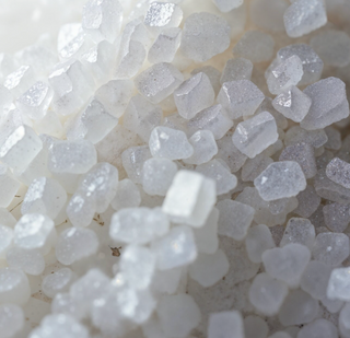 Close-up of white crystal-like magnesium stones on a white background