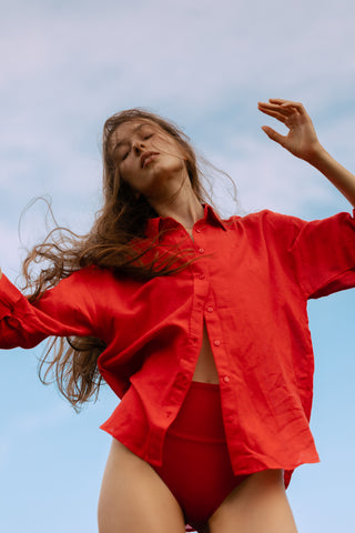 Person wearing a red outfit against a clear blue sky