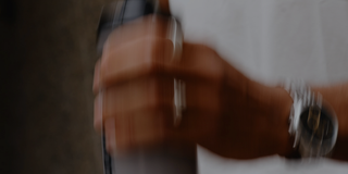 Hand holding a water bottle with a blurred background