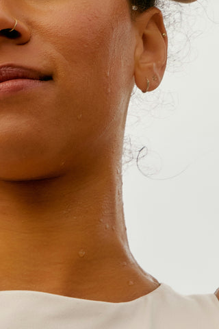 Close-up of a person's neck and shoulder with a neutral background