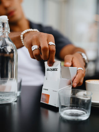 Person holding a Glojuice package with a blurred background